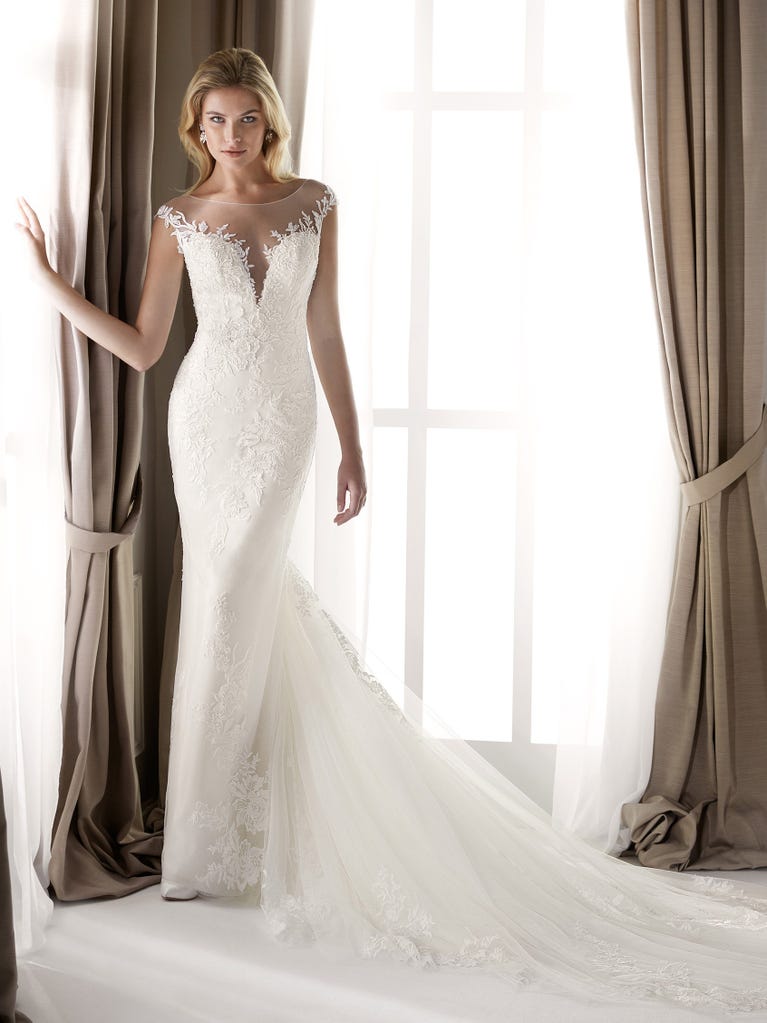 Fit & flare champagne tulle wedding dress with off-white guipure lace floral designs. The rounded neckline with tattoo-effect lace is highlighted with a refined, romantic 3D flower on the shoulder.