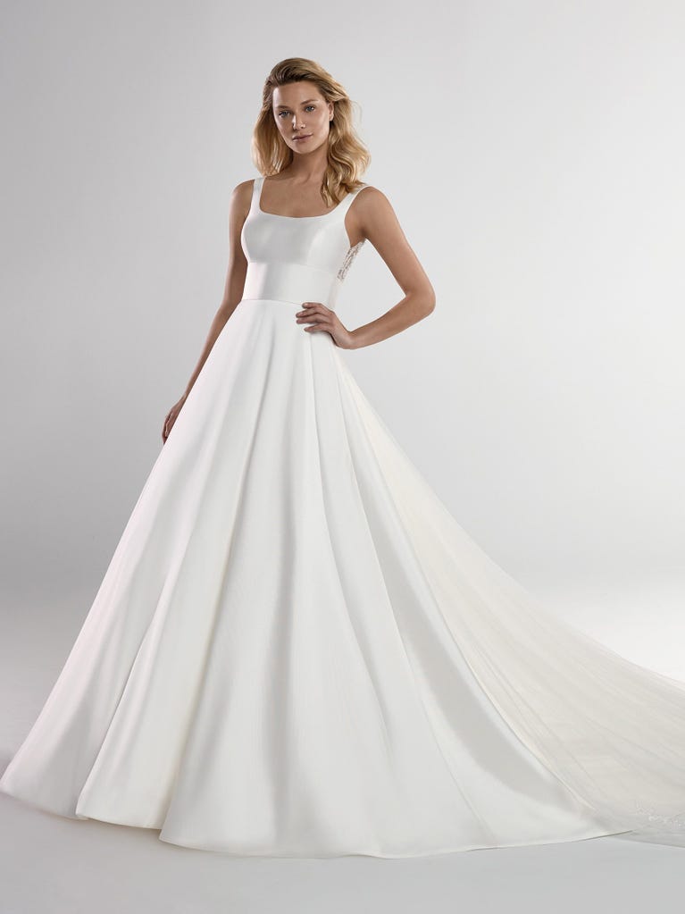 Fit & flare champagne tulle wedding dress with off-white guipure lace floral designs. The rounded neckline with tattoo-effect lace is highlighted with a refined, romantic 3D flower on the shoulder.