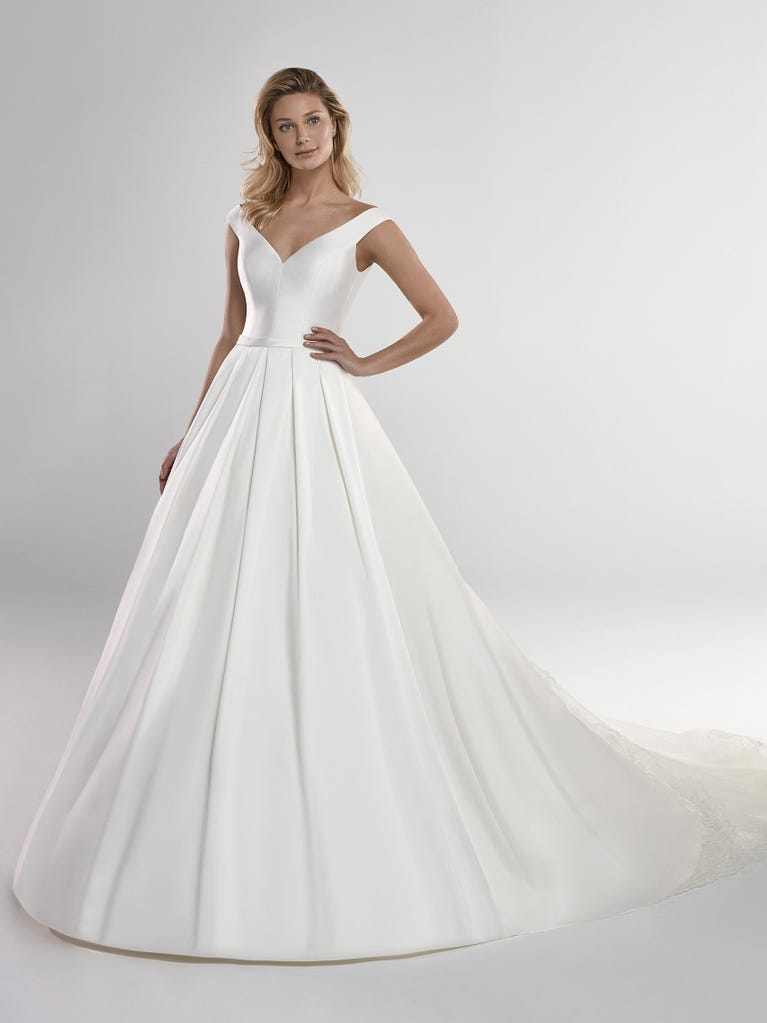 Fit & flare champagne tulle wedding dress with off-white guipure lace floral designs. The rounded neckline with tattoo-effect lace is highlighted with a refined, romantic 3D flower on the shoulder.