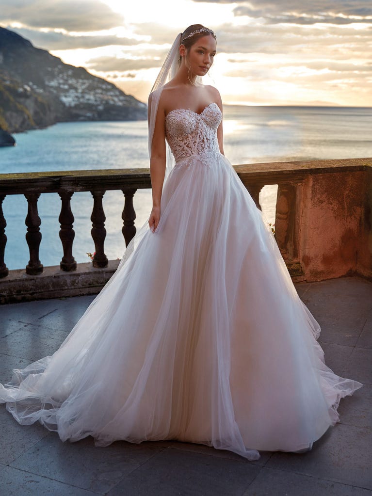 Tulle wedding dress with sleeveless bodice and sweetheart neckline. The embroidered lace creates a fabulous 3D effect, and the removable sleeves will look perfect during the ceremony.