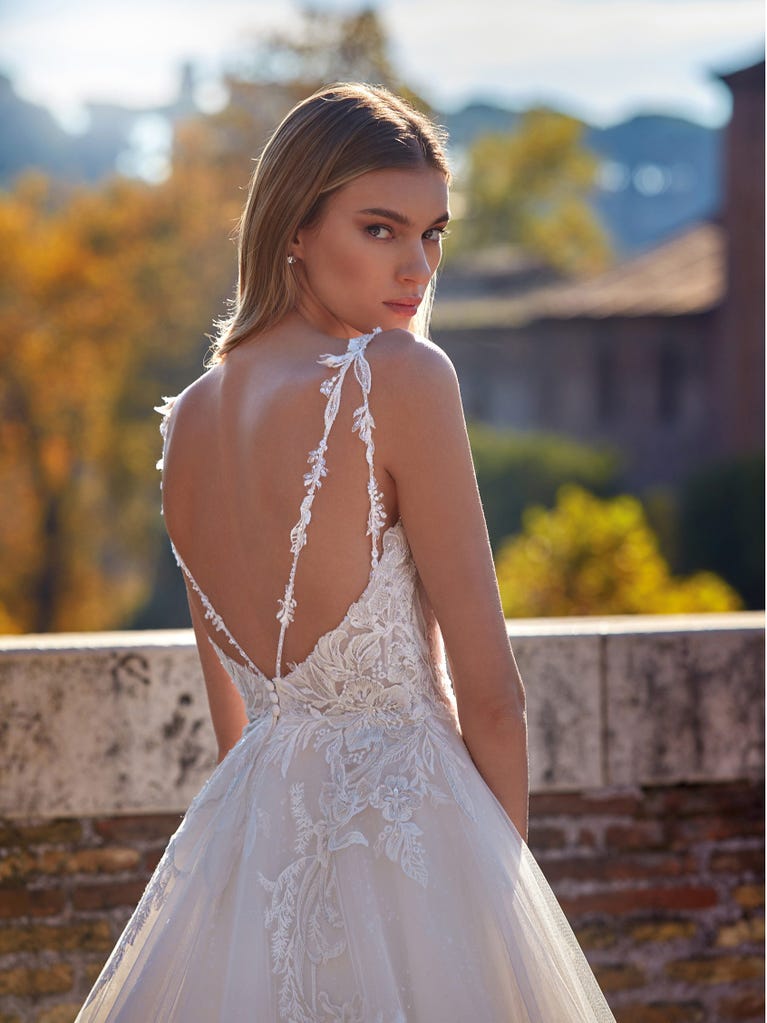 Tulle wedding dress with sleeveless bodice and sweetheart neckline. The embroidered lace creates a fabulous 3D effect, and the removable sleeves will look perfect during the ceremony.
