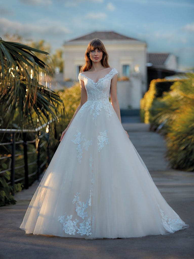 Tulle wedding dress with sleeveless bodice and sweetheart neckline. The embroidered lace creates a fabulous 3D effect, and the removable sleeves will look perfect during the ceremony.
