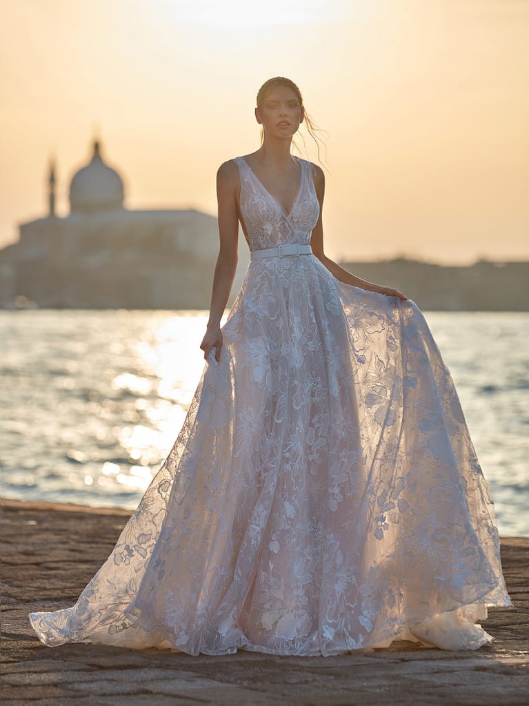 Tulle wedding dress with sleeveless bodice and sweetheart neckline. The embroidered lace creates a fabulous 3D effect, and the removable sleeves will look perfect during the ceremony.
