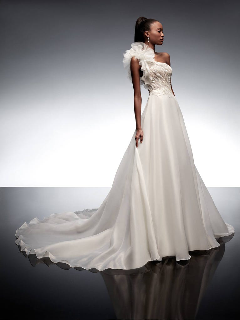 Precioso vestido de novia corte en A de tul champán con bordados de cuentas y elegantes flores 3D. Los tirantes dejan descubierta la espalda con un elegante escote.