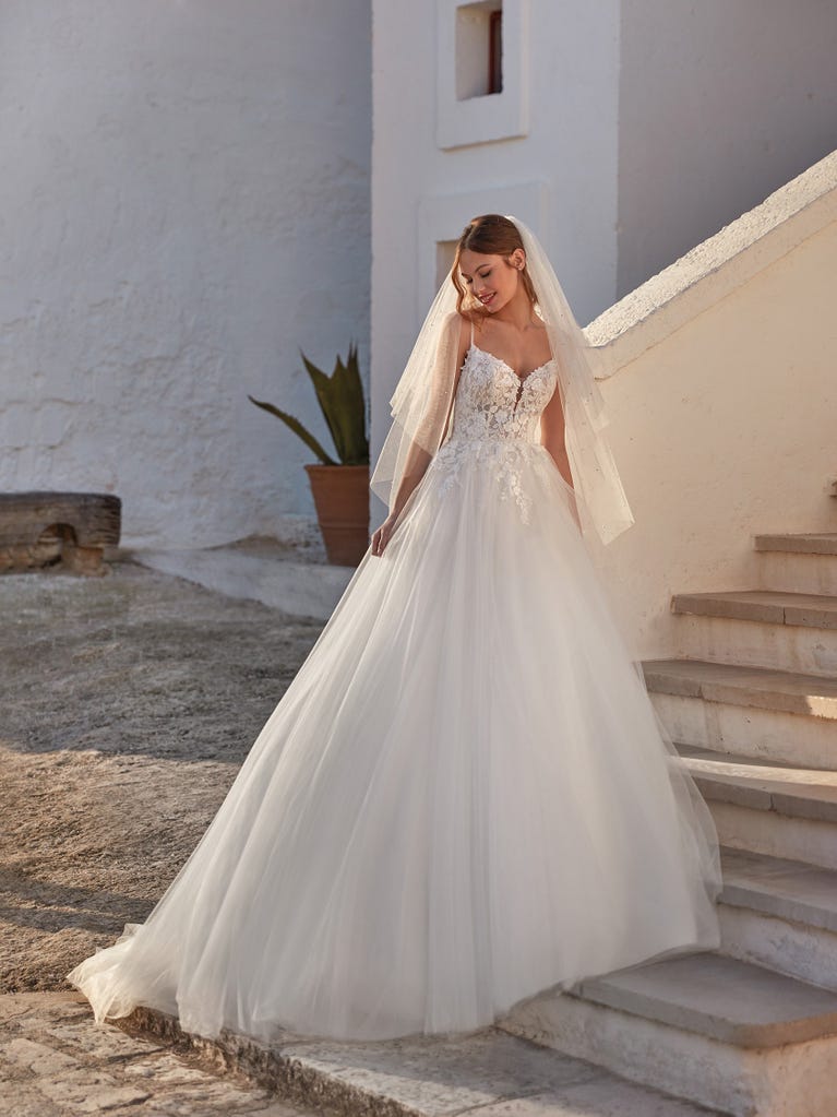 Tulle wedding dress with sleeveless bodice and sweetheart neckline. The embroidered lace creates a fabulous 3D effect, and the removable sleeves will look perfect during the ceremony.