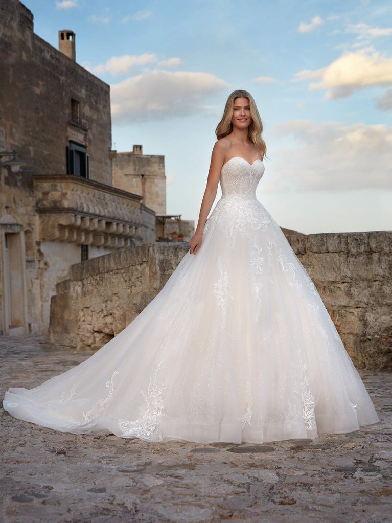 Tulle wedding dress with sleeveless bodice and sweetheart neckline. The embroidered lace creates a fabulous 3D effect, and the removable sleeves will look perfect during the ceremony.