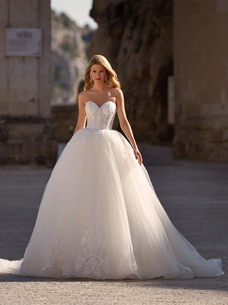 Tulle wedding dress with sleeveless bodice and sweetheart neckline. The embroidered lace creates a fabulous 3D effect, and the removable sleeves will look perfect during the ceremony.