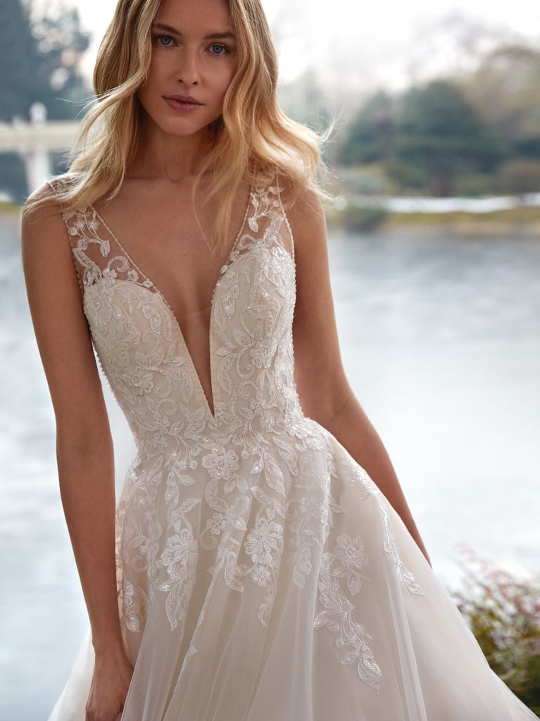 Tulle wedding dress with sleeveless bodice and sweetheart neckline. The embroidered lace creates a fabulous 3D effect, and the removable sleeves will look perfect during the ceremony.