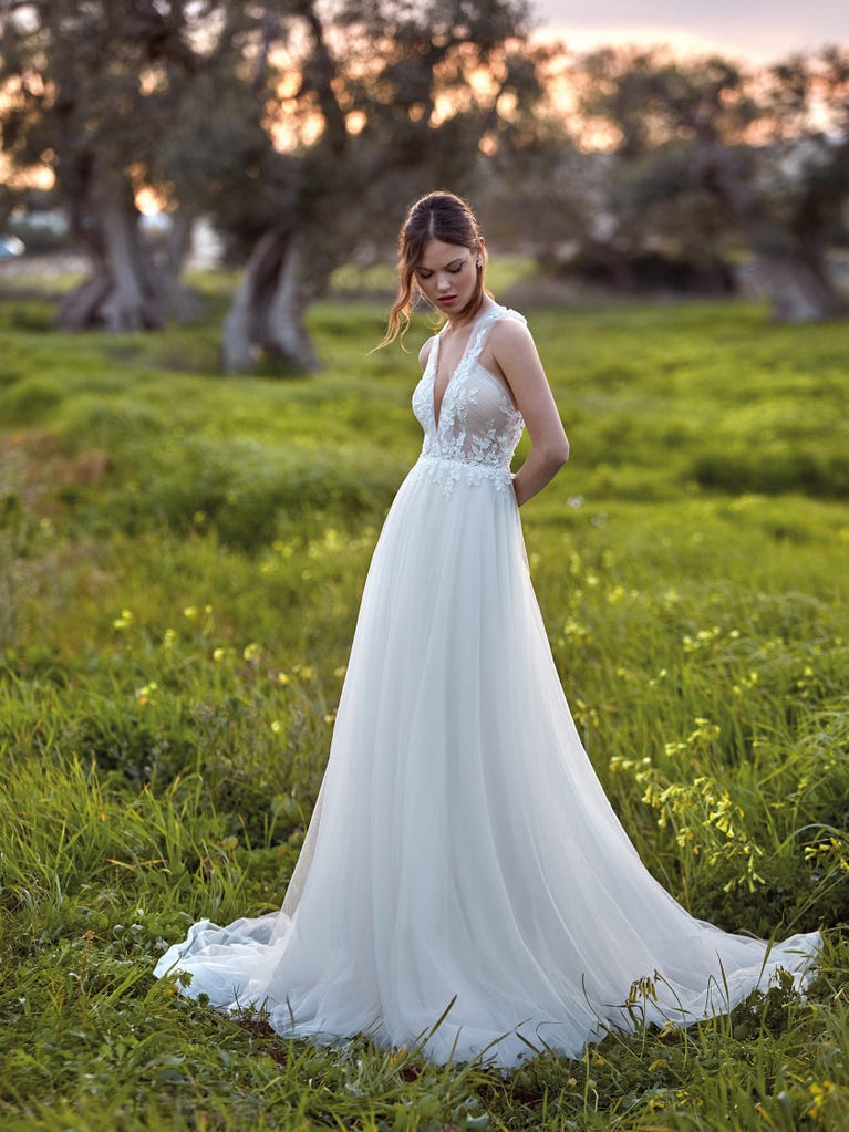 Flared wedding dress with voluminous yet lightweight tulle skirt with lace embroidered with floral motifs. For brides who dream of a romantic, feminine dress to say “I do.”