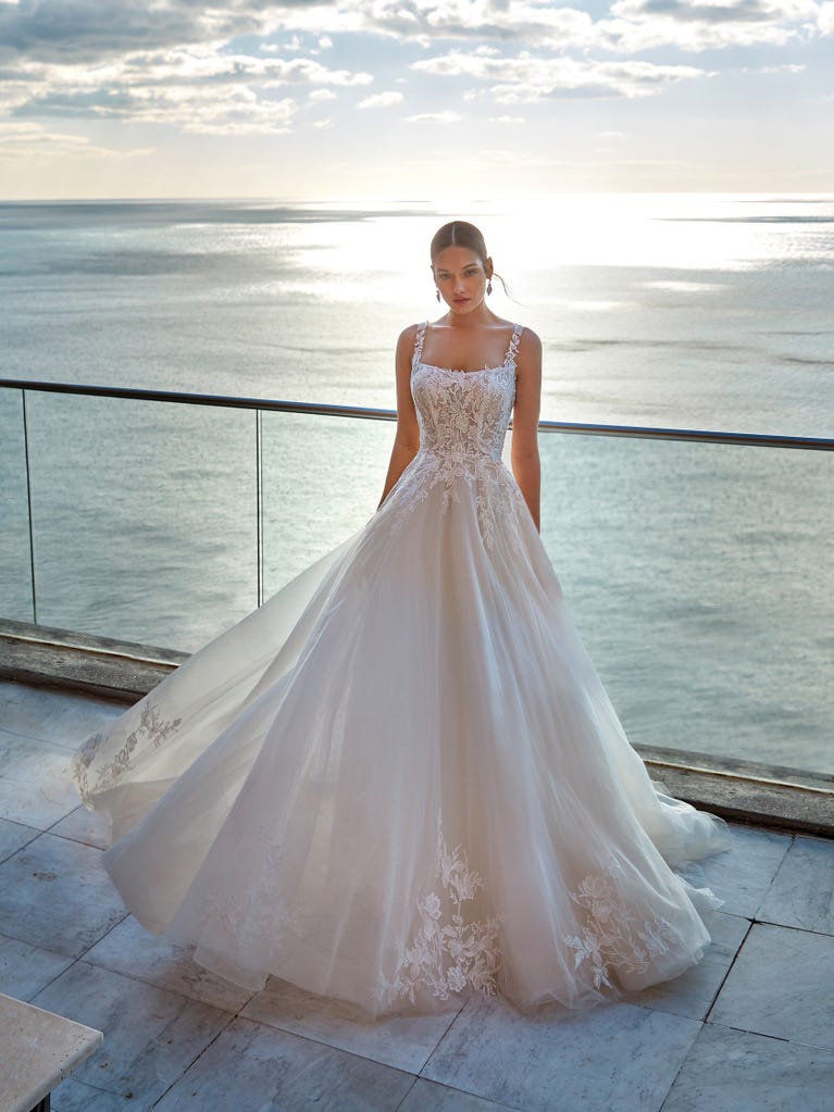 Tulle wedding dress with sleeveless bodice and sweetheart neckline. The embroidered lace creates a fabulous 3D effect, and the removable sleeves will look perfect during the ceremony.