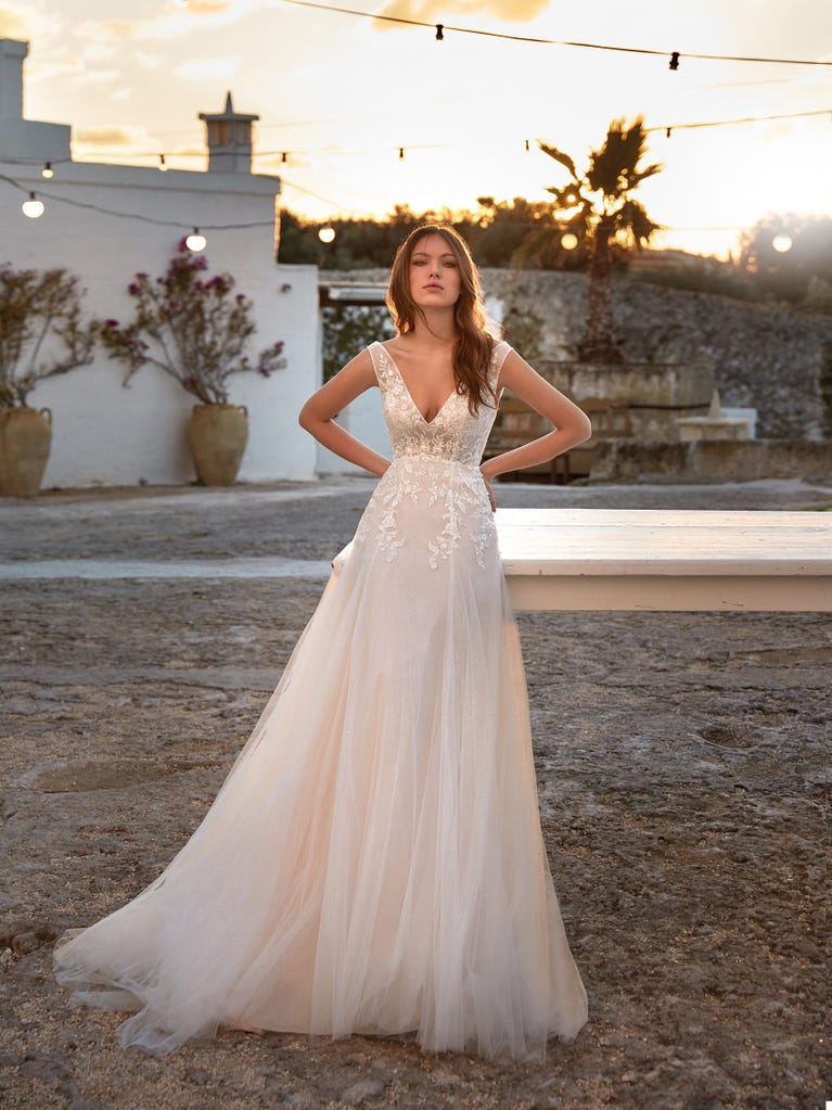 Flared wedding dress with voluminous yet lightweight tulle skirt with lace embroidered with floral motifs. For brides who dream of a romantic, feminine dress to say “I do.”