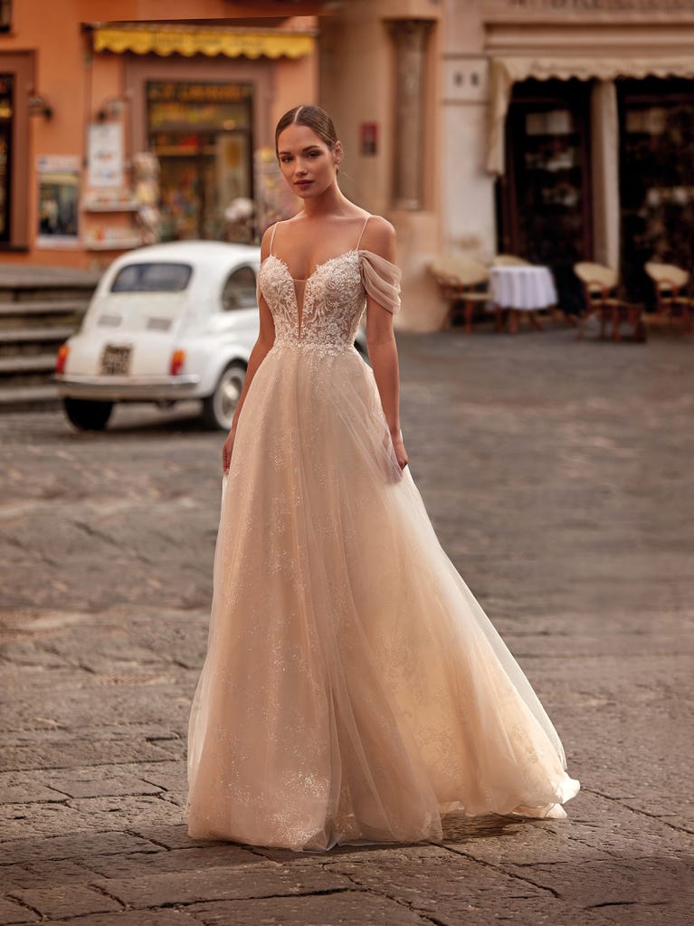 Tulle wedding dress with sleeveless bodice and sweetheart neckline. The embroidered lace creates a fabulous 3D effect, and the removable sleeves will look perfect during the ceremony.