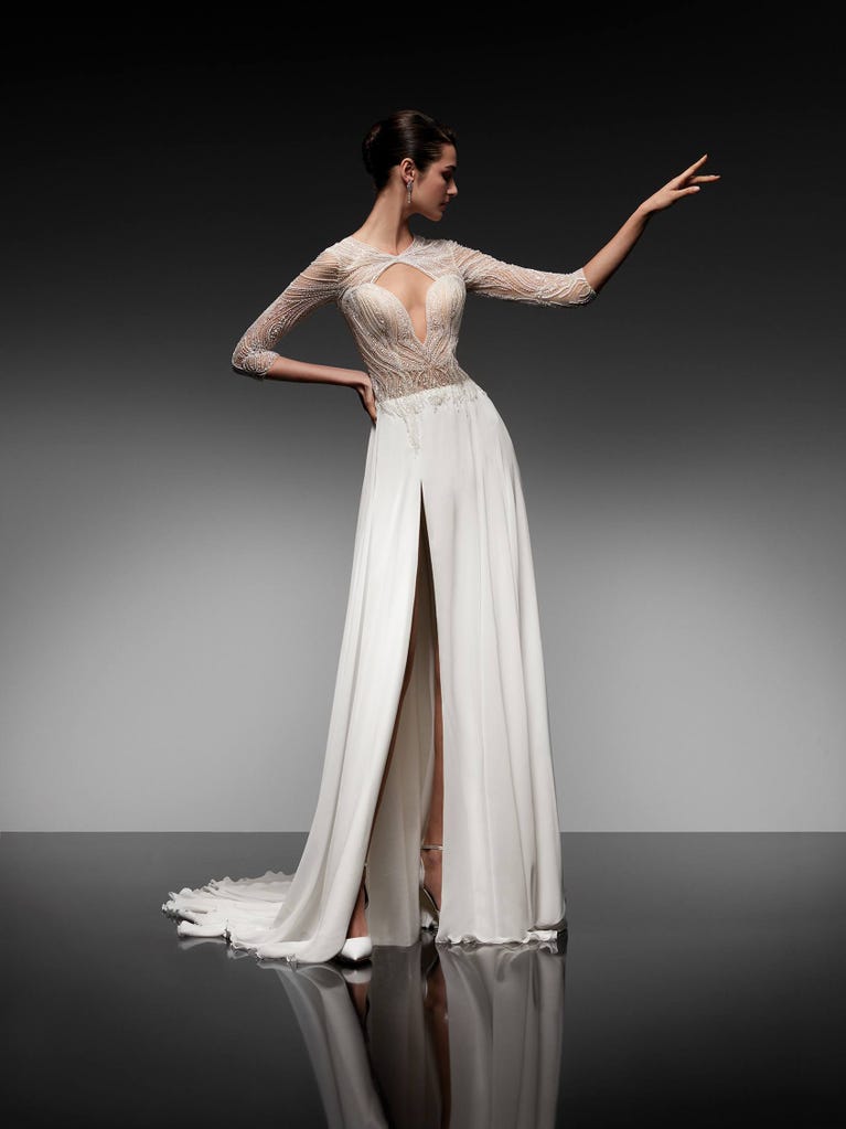 Beautiful A-line wedding dress in champagne tulle with embroidered beading and elegant 3D flowers. The straps expose the back with an elegant neckline.