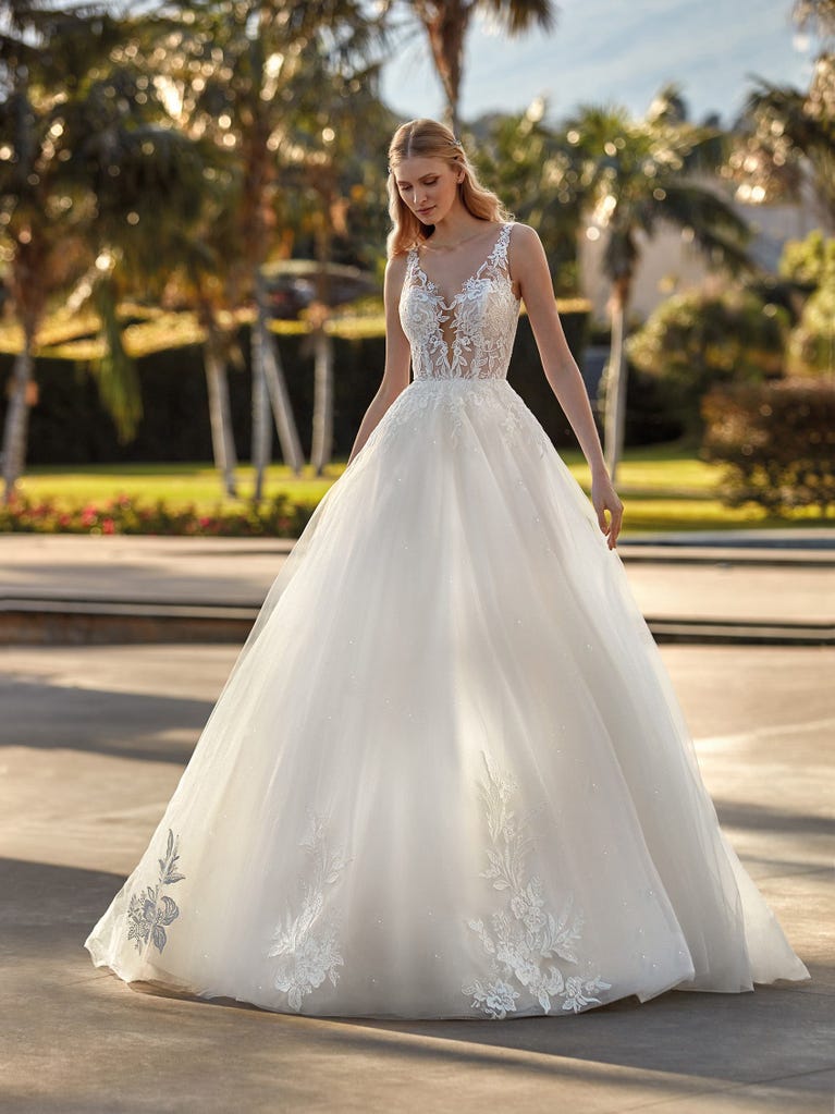Tulle wedding dress with sleeveless bodice and sweetheart neckline. The embroidered lace creates a fabulous 3D effect, and the removable sleeves will look perfect during the ceremony.