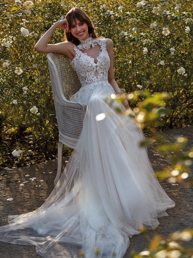 Flared wedding dress with voluminous yet lightweight tulle skirt with lace embroidered with floral motifs. For brides who dream of a romantic, feminine dress to say “I do.”