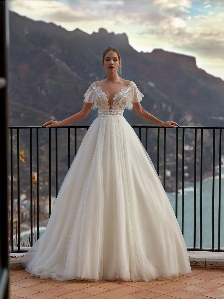 Tulle wedding dress with sleeveless bodice and sweetheart neckline. The embroidered lace creates a fabulous 3D effect, and the removable sleeves will look perfect during the ceremony.