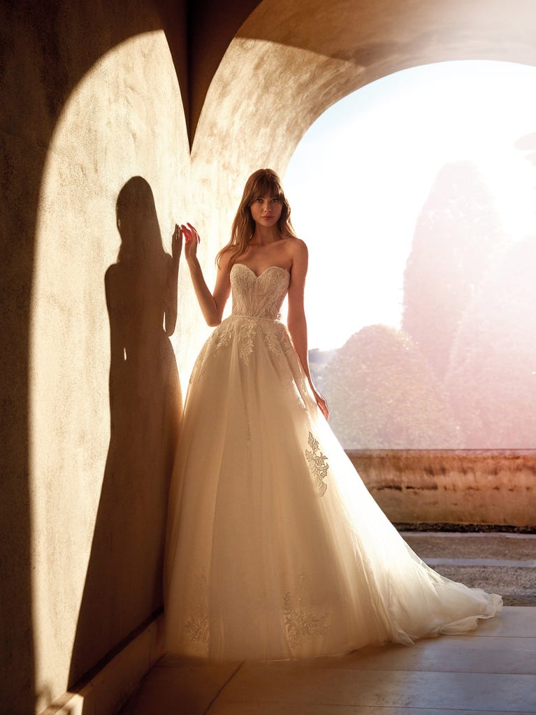 Tulle wedding dress with sleeveless bodice and sweetheart neckline. The embroidered lace creates a fabulous 3D effect, and the removable sleeves will look perfect during the ceremony.