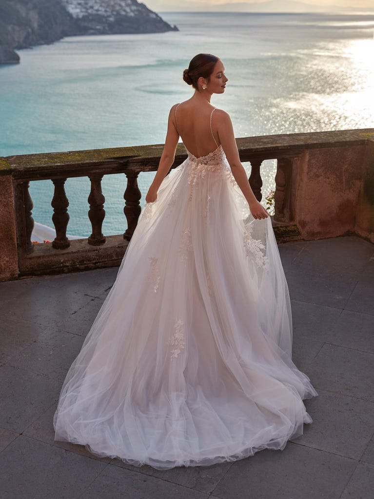 Flared wedding dress with voluminous yet lightweight tulle skirt with lace embroidered with floral motifs. For brides who dream of a romantic, feminine dress to say “I do.”