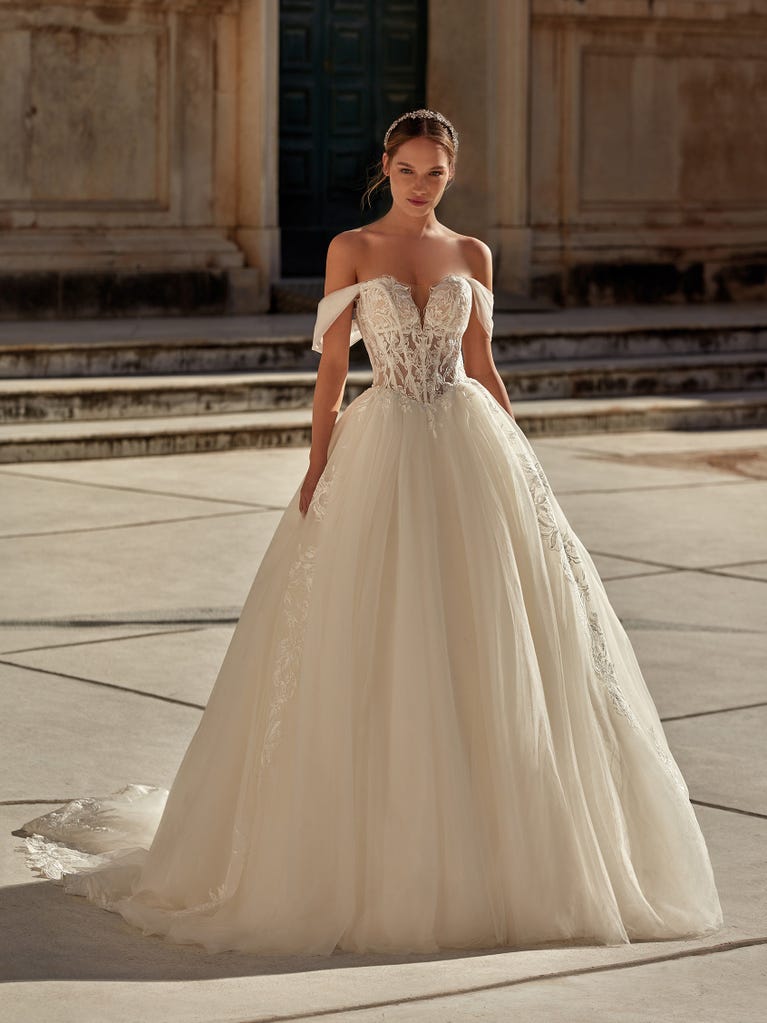 Tulle wedding dress with sleeveless bodice and sweetheart neckline. The embroidered lace creates a fabulous 3D effect, and the removable sleeves will look perfect during the ceremony.