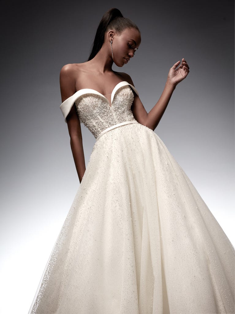 Tulle wedding dress with sleeveless bodice and sweetheart neckline. The embroidered lace creates a fabulous 3D effect, and the removable sleeves will look perfect during the ceremony.