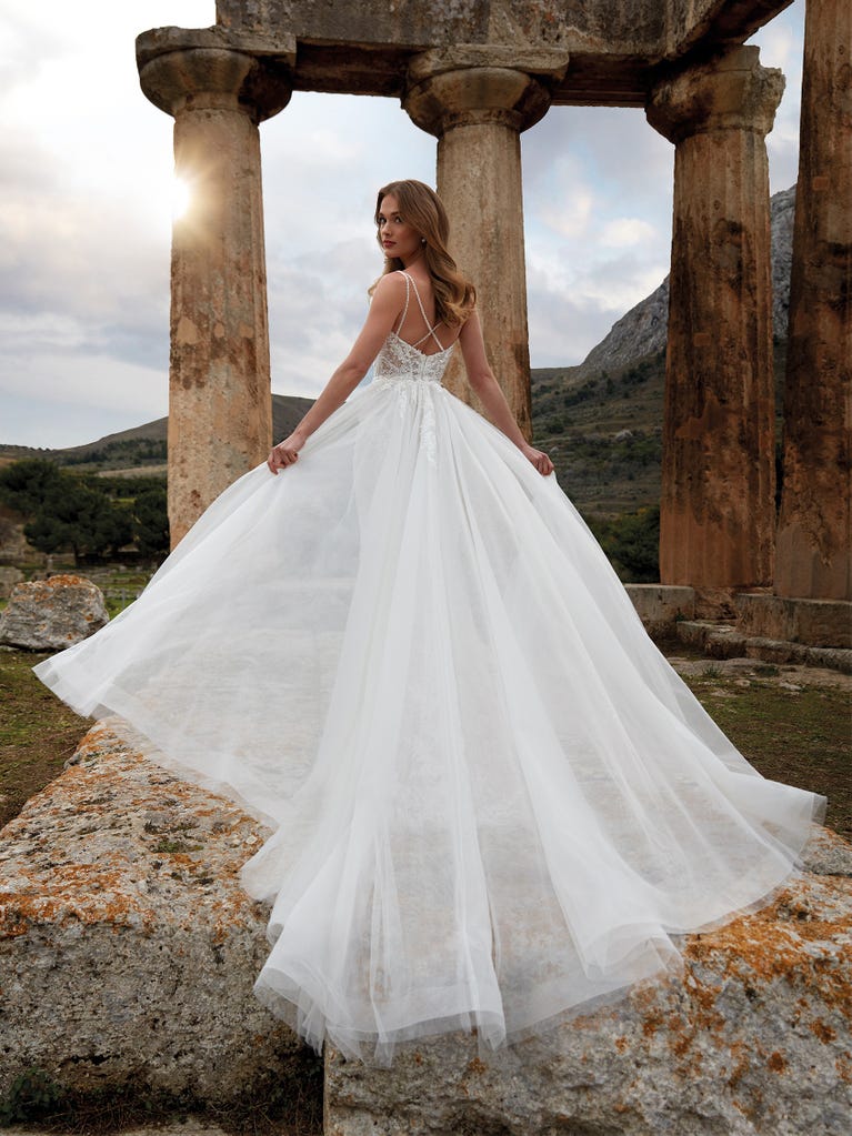 Princess wedding dress in carmine red tulle. The tulle ruffles create a light volume on the skirt and the sleeveless bodice, while the high waistline enhances the waist.