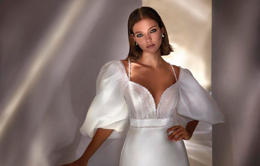 nueva-luxury-dream-cMujer con un vestido de novia con mangas abullonadas luciendo un peinado de novia sencilloapsule-collection