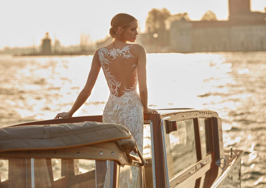 Mariée se tenant seule sur un bateau pour réaliser un élopement avec son futur époux.