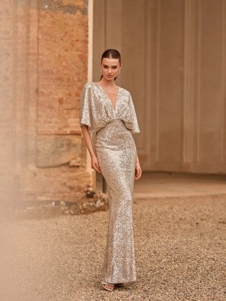 Mujer con vestido de invitada de boda de invierno dorado largo y brillante