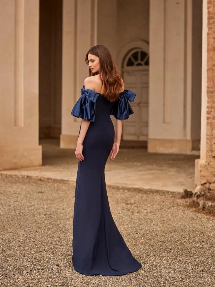 Mujer con vestido de invitada de boda de invierno azul con mangas con lazos