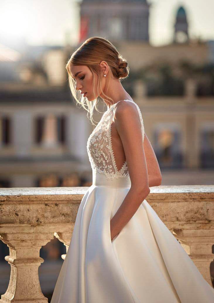 Une belle femme vêtue d’une robe de mariée trapèze en tulle arborant un élégant chignon